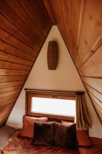 a bed in a room with a window in a attic at Bohema in Sierpnica