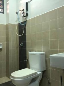 a bathroom with a white toilet and a sink at Evergreen 1 Homestay Kuantan in Kuantan