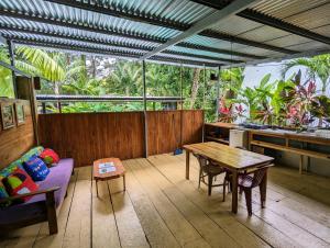 a screened in porch with a table and a couch at Arboura Eco Cabins in Uvita
