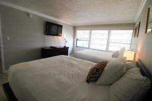 Een bed of bedden in een kamer bij 2/2 with Balcony, Direct Beach Access Resort Style Condo w/ 2 pools, jacuzzi