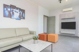 Vibe 305, Modern 2Bedroom Apartment in Awkar في Dbayeh: غرفة معيشة مع أريكة وطاولة