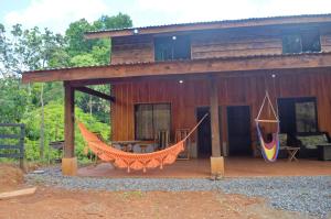 a house with a hammock in front of it at Capitan Morgan Homes & Tours in Pital