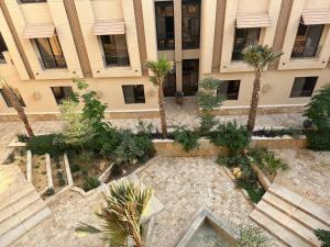 شقة فاخرة 3 غرف نوم وشرفة على الحديقة في الرياض: اطلالة جوية على مبنى يحتوي على ساحة مع نخيل