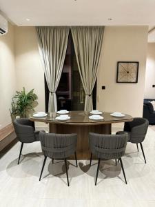 a dining table and chairs in a living room at شقة فاخرة 3 غرف نوم وشرفة على الحديقة in Riyadh