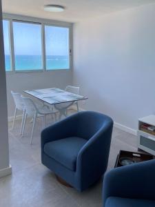 salon z niebieskim krzesłem i stołem w obiekcie KASA Blue Ocean - 2 bed 2 bath for 4 OCEAN VIEW BALCONY BEACHFRONT CONDO POOL w mieście San Juan