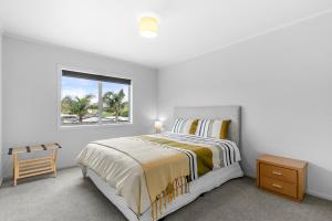 Habitación blanca con cama y ventana en Space on Spinifex - Mangawhal Heads Holiday Home, en Mangawhai