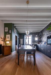 una sala da pranzo con tavolo e una cucina di Grande Maison Cusset - Maison de ville - 3 chambres a Cusset
