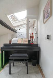 a black piano in a room with a skylight at Grande Maison Cusset - Maison de ville - 3 chambres in Cusset