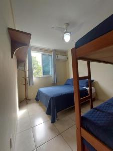 1 dormitorio con 2 literas y ventana en Aconchego da Prainha dois quartos, ar condicionado, wifi , duas vagas de garagem, en Arraial do Cabo