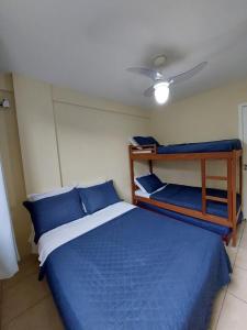 1 dormitorio con 1 cama y 2 literas en Aconchego da Prainha dois quartos, ar condicionado, wifi , duas vagas de garagem, en Arraial do Cabo