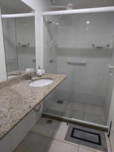 y baño con lavabo y ducha acristalada. en Aconchego da Prainha dois quartos, ar condicionado, wifi , duas vagas de garagem, en Arraial do Cabo