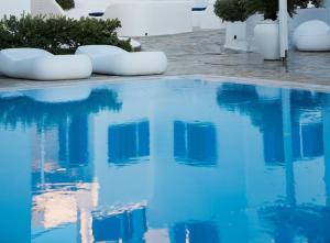 una grande piscina con acqua blu in un cortile di Capari Maisonette Mykonos Town Villa with Shared Pool a Mykonos Città