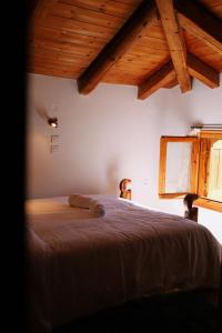 ein Schlafzimmer mit einem Bett in einem Zimmer mit Holzdecken in der Unterkunft Diminio 1 Whole House - Chalet in Arachova