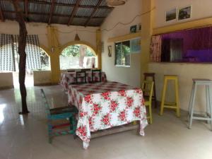 Cette chambre comprend une table avec un tissu de table rouge et blanc. dans l'établissement Campement Kunja, à Kafountine