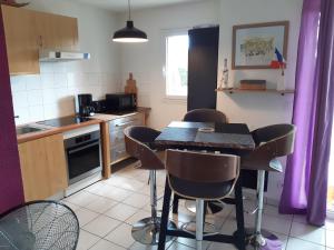 a kitchen with a table and chairs in a kitchen at Domaine des Pins Audenge Bassin d'Arcachon in Audenge