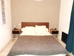 una camera da letto con un grande letto con due comodini di Domaine des Pins Audenge Bassin d'Arcachon ad Audenge