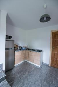 a kitchen with a stainless steel refrigerator and wooden cabinets at Willa Pod Jasieniami -basen plac zabaw in Białka Tatrzanska