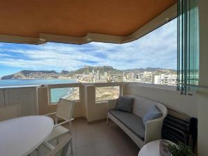 balcón con mesa, sillas y vistas al océano en Apartamentos Rubino (13º-B), en Calpe