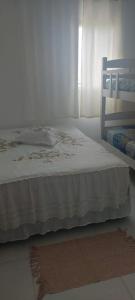 - une chambre avec un lit doté d'un couvre-lit blanc dans l'établissement Ap. Condominio da Fé c/ Garagem e Ar Condicionado, à Cachoeira Paulista