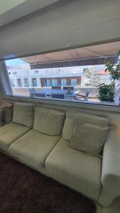 a couch in a living room with a large window at Macrisbete 4 in Fátima