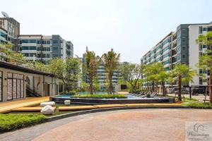 Ban Khlong Samrongにある素坤逸展會雅居樂酒店式公寓のヤシの木や建物が茂る噴水のある公園