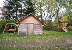 a small cabin with a swing and a playground at Willa Pod Jasieniami -basen plac zabaw in Białka Tatrzanska