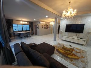 a living room with a couch and a tv at Tawan House in Pattaya North