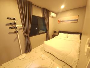 a small bedroom with a bed and a window at Tawan House in North Pattaya