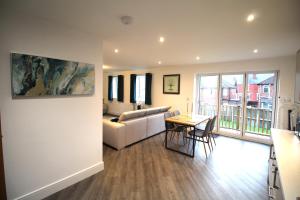 a living room with a couch and a table at Rawmarsh - Great Customer Feedback - 2 Bed Bungalow - New Build - High End Furnishings - Wheel Chair Accessible - Large Enclosed Garden - Dog Friendly in Rotherham