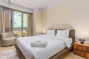 Un dormitorio con una gran cama blanca y una ventana en Symphony 1 Bedroom Apartment in Solidere, en Beirut