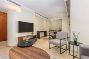 a living room with a tv and a table and chairs at Symphony 1 Bedroom Apartment in Solidere in Beirut