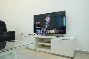- un salon avec une télévision sur une table blanche dans l'établissement Hawana Premium Hostel, à Dubaï