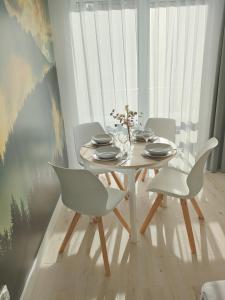 ein Esszimmer mit einem weißen Tisch und Stühlen in der Unterkunft White Apartament Szklarska Poręba in Szklarska Poręba
