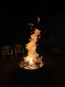 eine Feuerstelle mit zwei Stühlen daneben in der Unterkunft Moksha Infinity Valley in Kotagiri