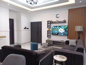 a living room with couches and a flat screen tv at Masayi Residences in Adentan