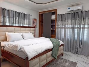 a bedroom with a large bed and a window at Masayi Residences in Adentan