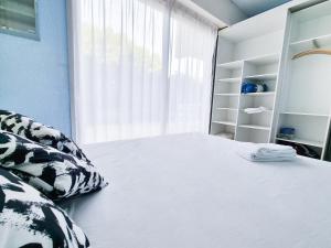 1 dormitorio con cama y ventana grande en T2 Mer 50m - Clim YourHostHelper, en Bormes-les-Mimosas