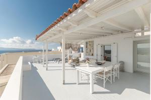 a white house with a table and chairs on a roof at Aegeas Secret in Naxos Chora