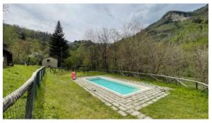 uma piscina num campo ao lado de uma cerca em Luxury suite la Grotta del Vento em Gallicano