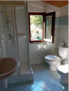 uma casa de banho com um WC, um chuveiro e um lavatório. em Luxury suite la Grotta del Vento em Gallicano