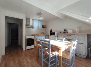 eine Küche mit einem Tisch und Stühlen im Zimmer in der Unterkunft Appartement avec vue sur le Sancy, parking gratuit in Le Mont-Dore