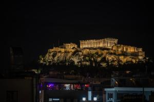 budynek na szczycie góry w nocy w obiekcie Athens Genesis Luxury Suites w Atenach