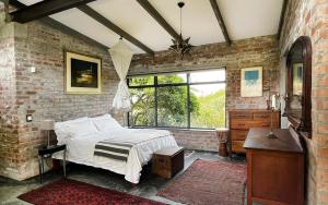 sypialnia z łóżkiem i ceglaną ścianą w obiekcie Brickhouse w mieście Monteray