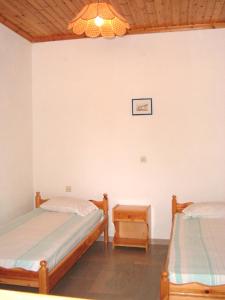 a bedroom with two twin beds and a chandelier at IONIO Apartments in Lefkímmi