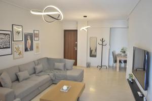 a living room with a couch and a tv at Be My Guest in Tríkala