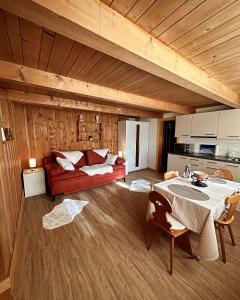ein Wohnzimmer mit einem roten Sofa und einem Tisch in der Unterkunft Meieli's Chalet in Hofstetten 