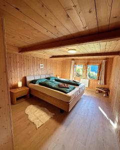 ein Schlafzimmer mit einem großen Bett in einer Hütte in der Unterkunft Meieli's Chalet in Hofstetten 