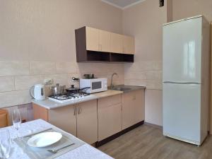 a kitchen with a white refrigerator and a sink at Синя квартира. Мережа Alex Apartments. Цілодобове безконактне заселення 24-7 in Poltava