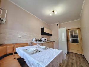 a kitchen with a white table and a refrigerator at Синя квартира. Мережа Alex Apartments. Цілодобове безконактне заселення 24-7 in Poltava