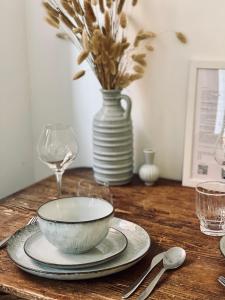 a wooden table with a bowl and a vase with flowers at Le Chalet de la Plage in Sévrier